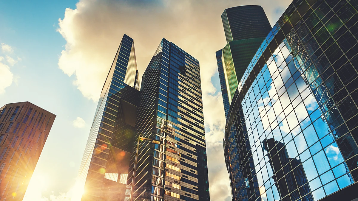 Sun shining in between skyscrapers in an urban environment